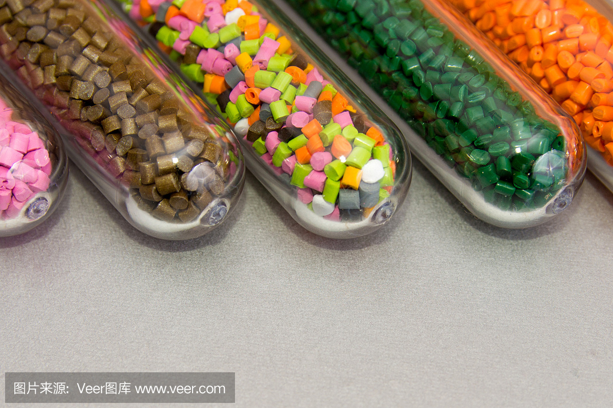 塑料颗粒,灰色背景下试管中的聚合物染料。